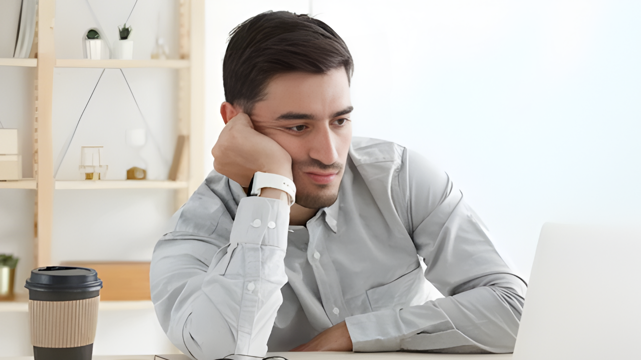 Person stressed looking at tax forms and calculator